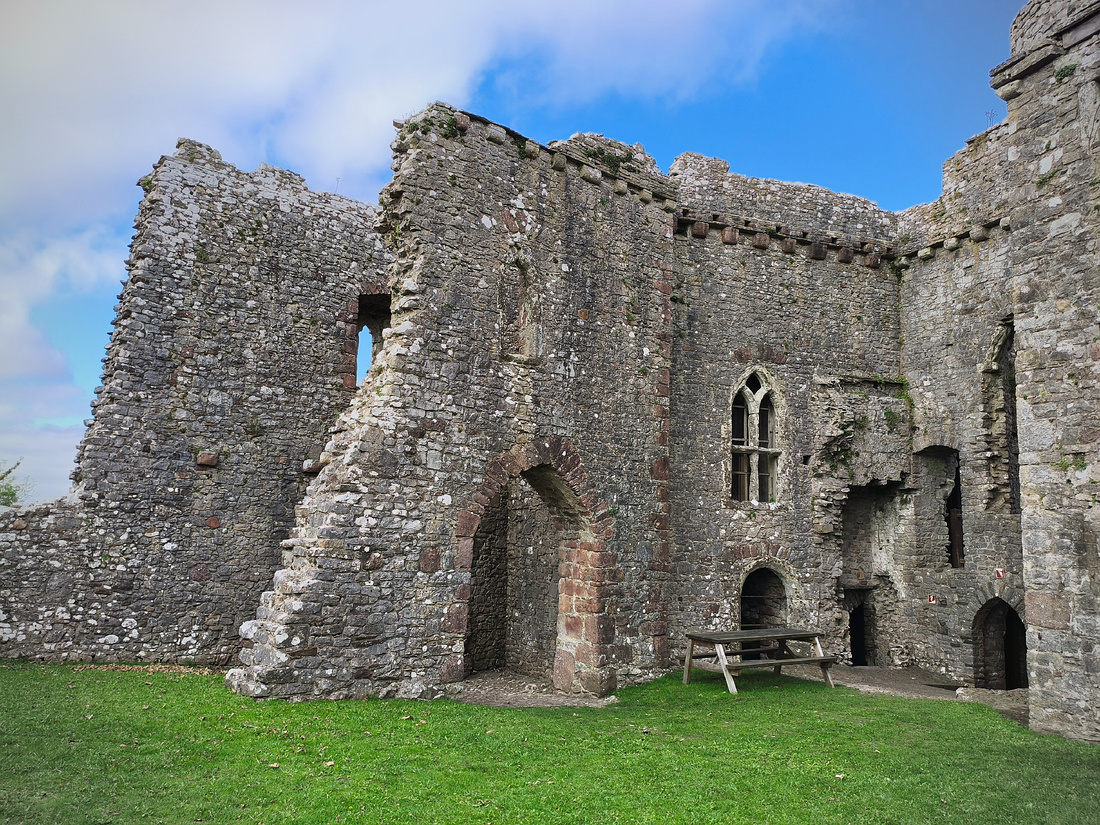 Photographie de ruines, qui semblent former un château. Les pierres sont de couleur grise et forment une structure imposante.